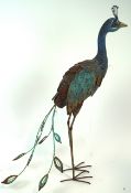 A cut out painted model of a peacock, the wings mounted en tremblant,