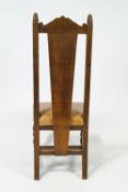 A set of four oak dining chairs with carved arched cresting rail above a carved solid splat