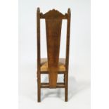 A set of four oak dining chairs with carved arched cresting rail above a carved solid splat