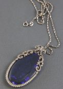 A white metal Edwardian style pendant principally set with an oval cabochon cut black opal