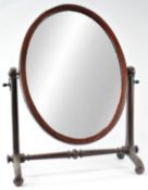 A Victorian mahogany swing frame mirror, of oval form with flared supports issuing scroll feet,