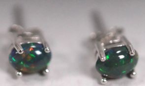 A white metal pair of single stone stud earrings.