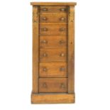 An oak Wellington chest, set with seven drawers, with a plain top raised on acanthus brackets,