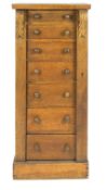 An oak Wellington chest, set with seven drawers, with a plain top raised on acanthus brackets,