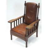 An early 20th century Art & Crafts oak lounge chair, having stuffed and brown leather upholstery,