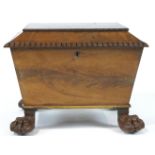 A William IV mahogany cellarette, of sarcophagus form, on carved paw feet, enclosing brass casters,