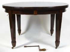 An Edwardian mahogany dining table with wind out action to encompass two leaves,