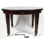 An Edwardian mahogany dining table with wind out action to encompass two leaves,