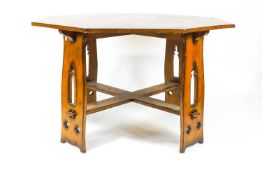 An oak Arts and Crafts style octagonal table, on four pierced legs, linked by flat stretchers,