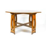 An oak Arts and Crafts style octagonal table, on four pierced legs, linked by flat stretchers,