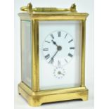 A brass carriage clock with alarm, with five glass panels and a white enamel Roman dial,