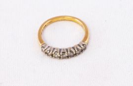 A yellow and white metal half hoop ring set with seven graduated round brilliant cut diamonds.