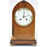 An Edwardian mahogany and boxwood strung lancet shaped mantel clock on gilt paw feet,