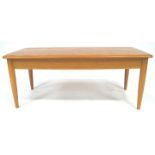 An Ercol elm wood coffee table with shaped rectangular top on plain legs,