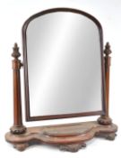 A Victorian mahogany swing mirror, of arched form, supported by fluted flared columns,