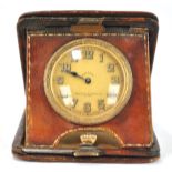 An early 20th century eight day travel clock in leather case, the dial inscribed Pearce & Sons Ltd,