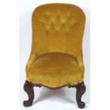 A Victorian button back nursing chair, on carved mahogany cabriole legs,