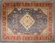 A wool rug with central flower filled medallion on a flower filled blue ground with spandrels