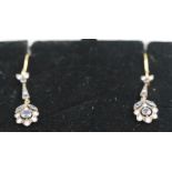 A yellow and white metal pair of floral design drop earrings set with round cut sapphires