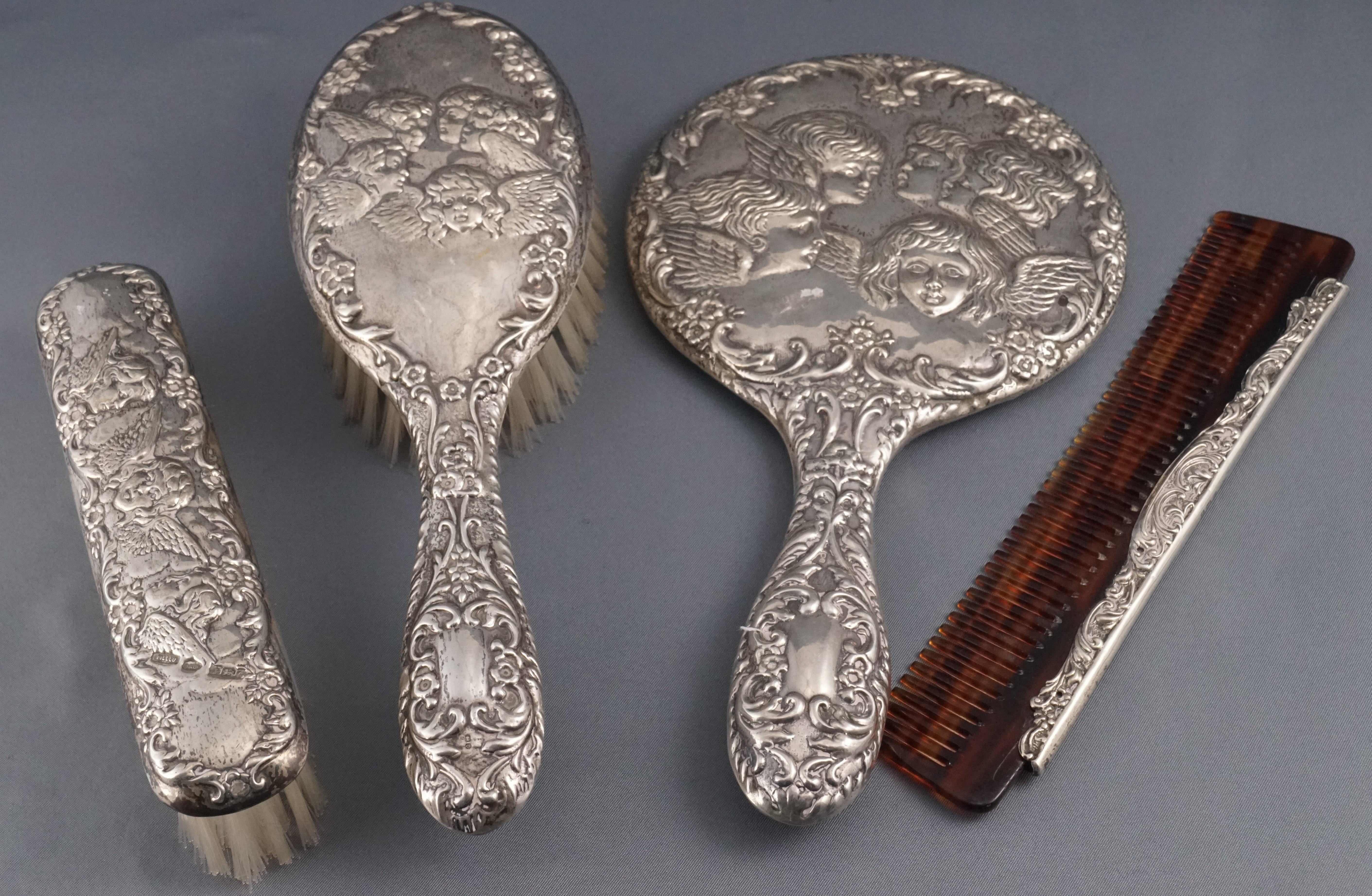 A ladies loaded silver dressing set, comprising : a hand mirror, two brushes and a comb,