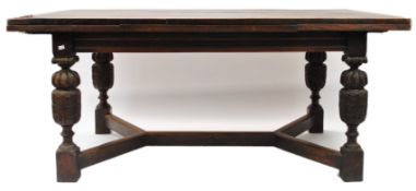 An oak extending dining table, of rectangular form, raised on acanthus carved cup and cover legs,