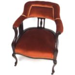 An Edwardian mahogany tub style nursing chair with padded back back over three pierced splats