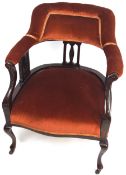An Edwardian mahogany tub style nursing chair with padded back back over three pierced splats