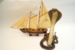 A resin figure of a cobra and a model of a boat