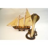 A resin figure of a cobra and a model of a boat