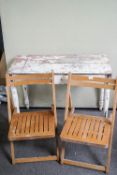 A pine table and two folding chairs