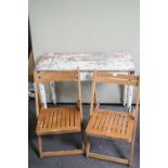 A pine table and two folding chairs