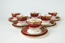 A Minton dark pink ground part tea service with gilt borders of leafy tendrils,