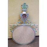 A metal wall mirror with foliate urn crest