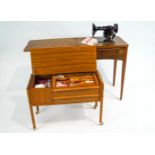 A Singer sewing machine table and a teak sewing table