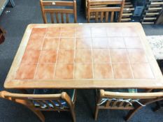 A tile top kitchen table and a set of four chairs