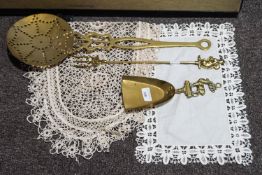 Three pieces of fireside brass ware and two table mats