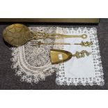 Three pieces of fireside brass ware and two table mats