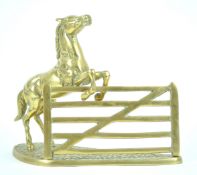 A brass figure of a horse jumping a five bar gate, styled as a letter rack,