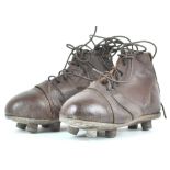 A pair of brown leather child's rugby boots,