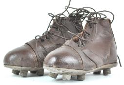 A pair of brown leather child's rugby boots,