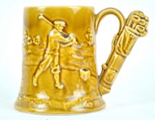 A pottery tankard, moulded with a golfing scene, the handle in the form of a bag of golf clubs,