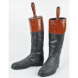 A pair of plastic life size hunting boots with simulated wooden trees,
