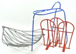 Two hay feeders together with a standing saddle rack and three hanging saddle racks