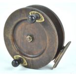 A hardwood fishing reel with ebonised handle,