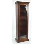 An oak gun cabinet for three guns, with glazed door on a plain plinth,