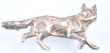 A white metal stock pin in the form of a running fox,