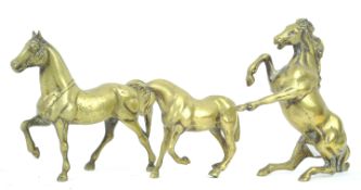 Three brass figures of horses in various stances,