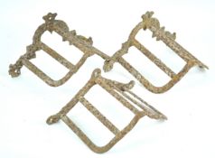 A pair of cast iron bridle racks, together with another similar,