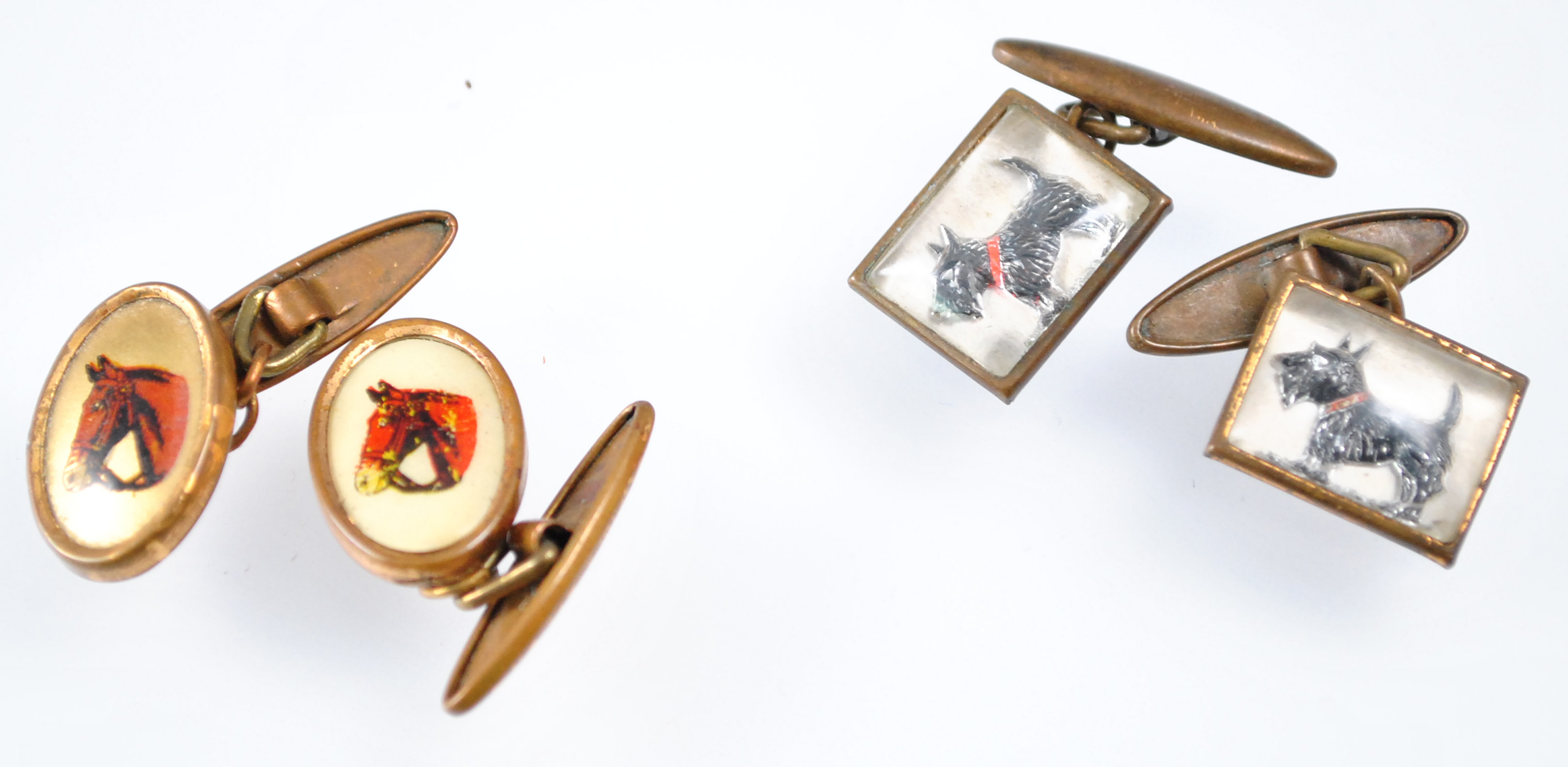 A pair of cufflinks, each printed with a hunter horses head,