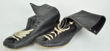 A pair of black leather boxing boots with white shoe laces,